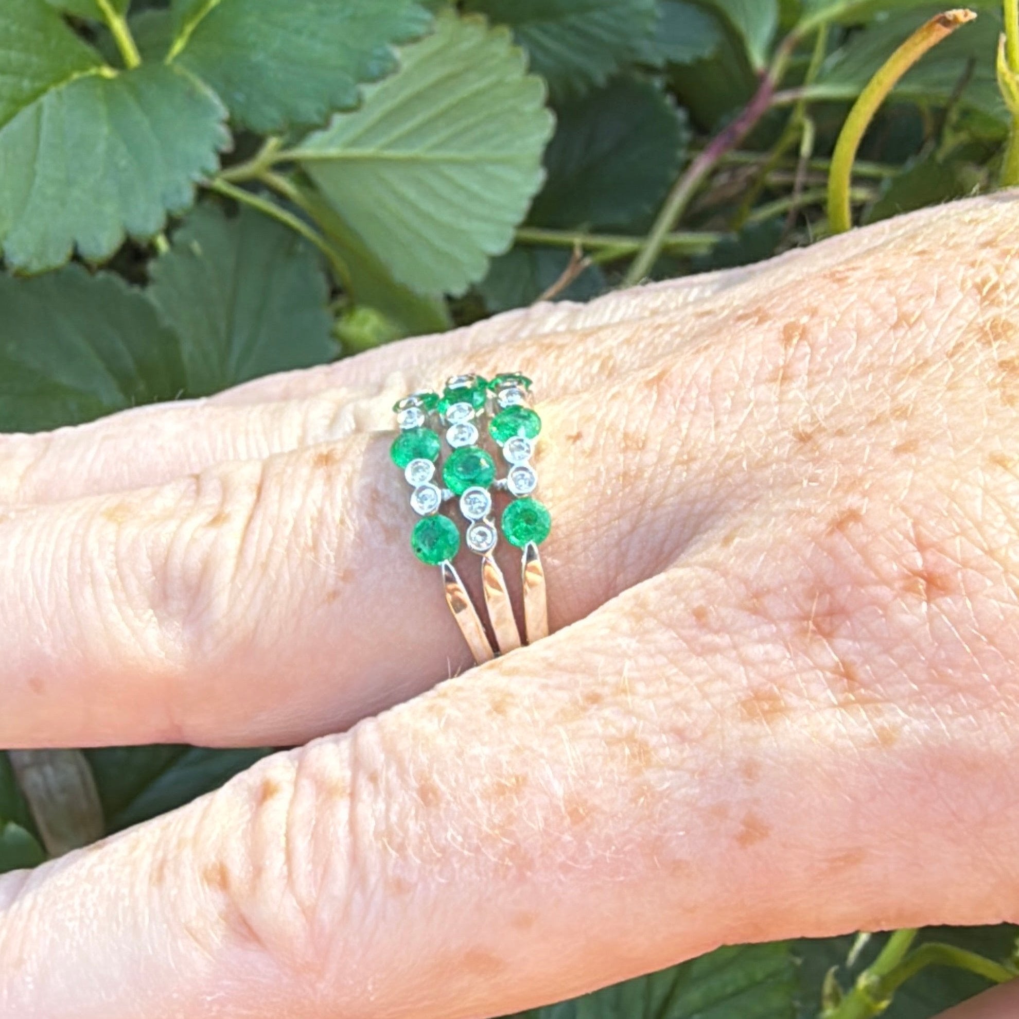 Green emerald diamond and white gold ring on hand side view
