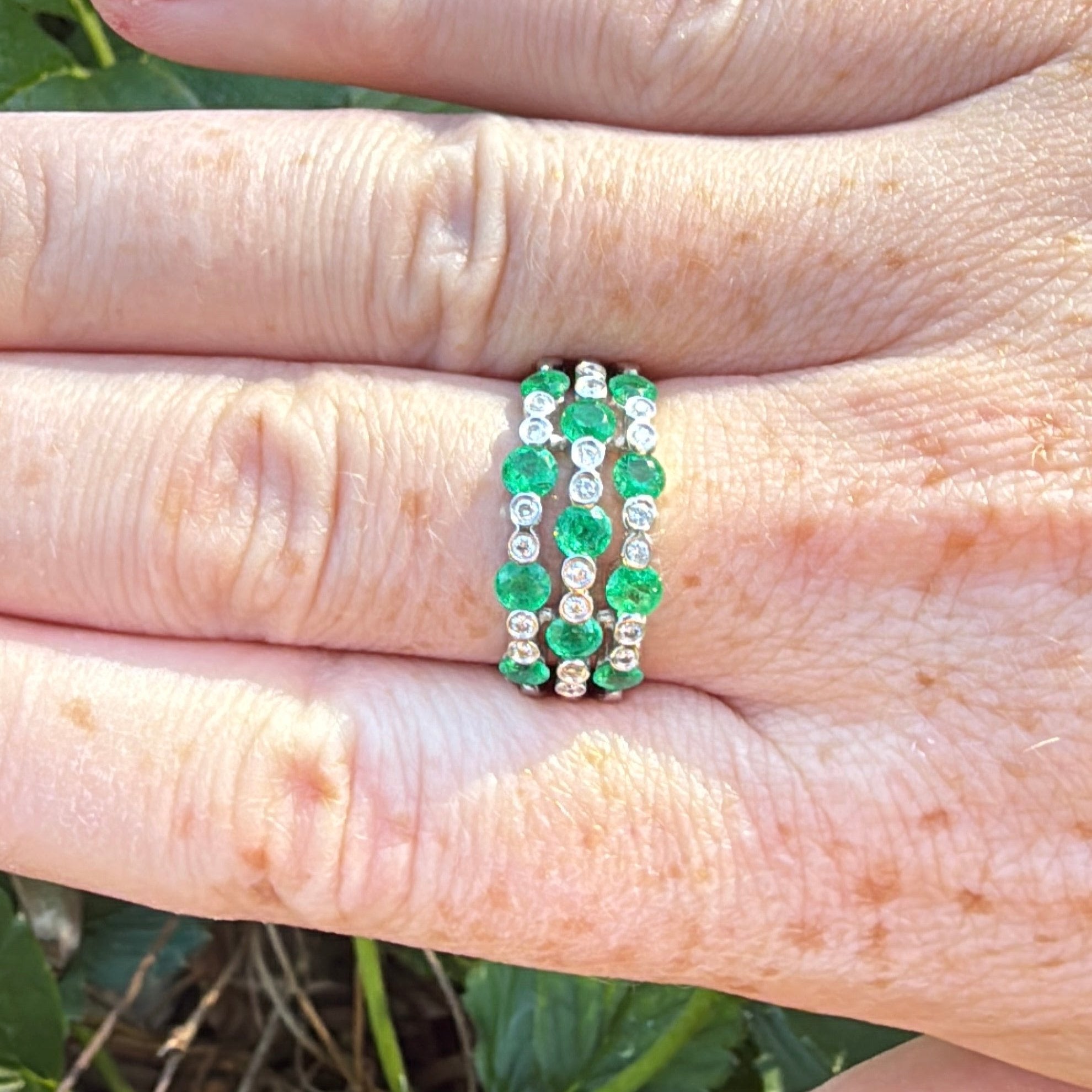 Green emerald diamond and white gold ring on hand