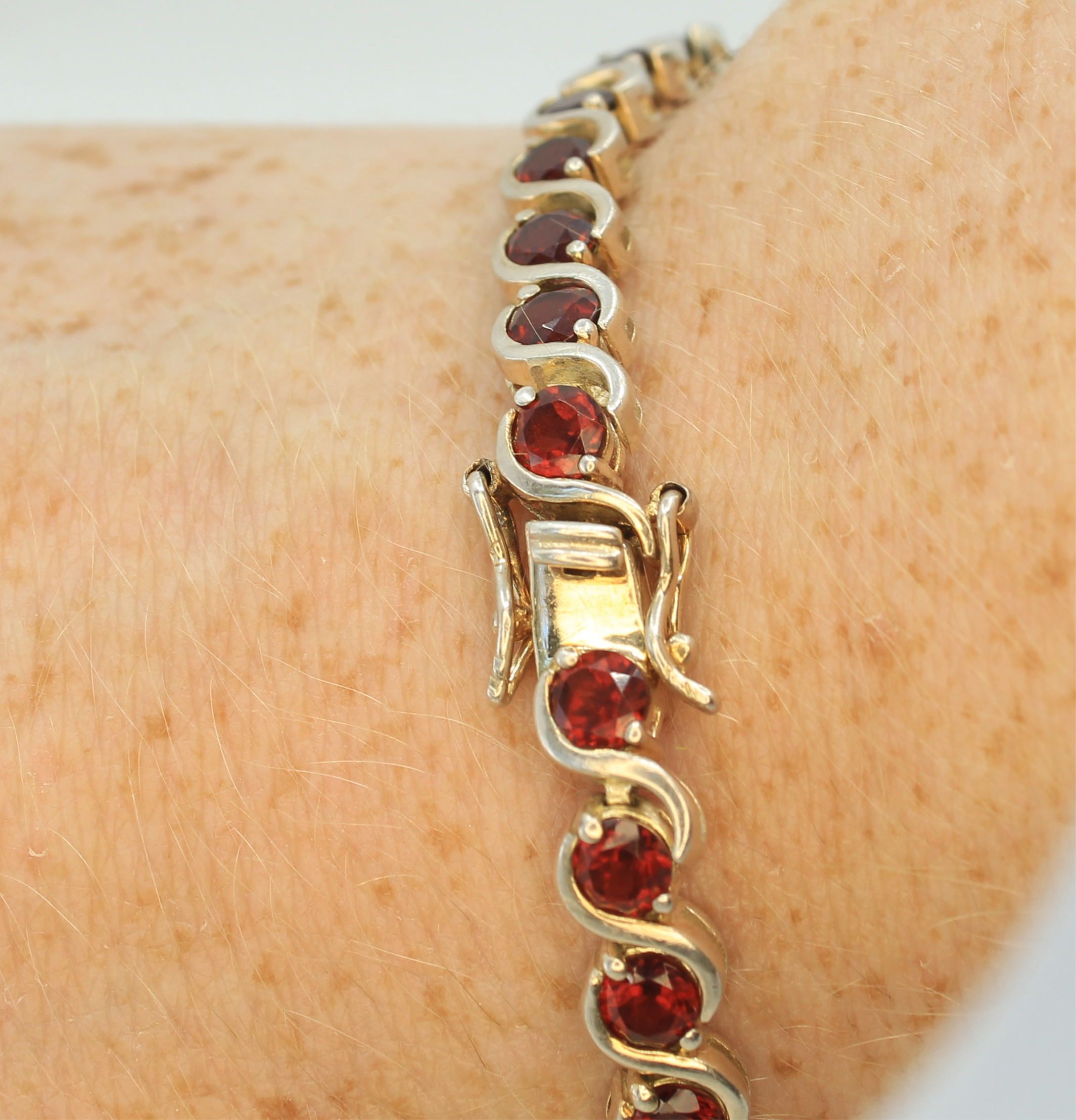 Close up of the red garnet tennis bracelet latch and backup lock.