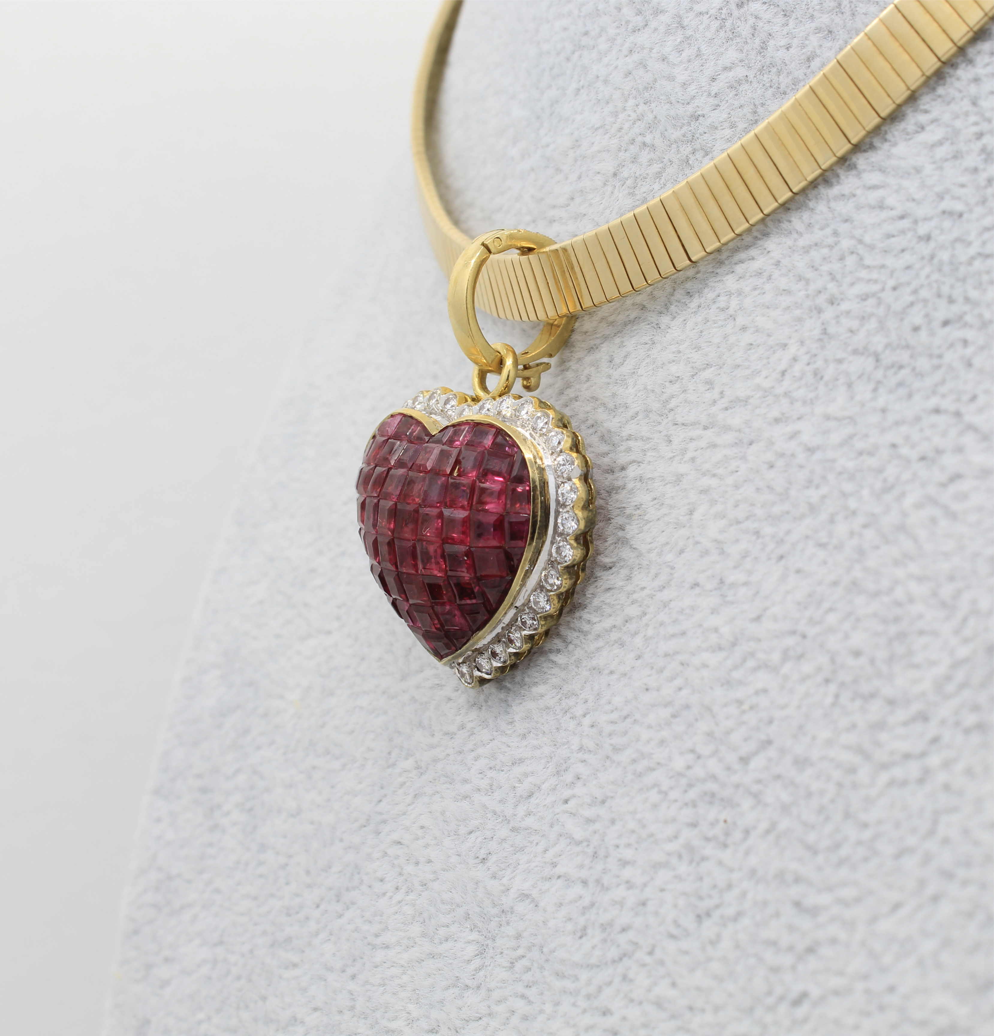 invisible set ruby heart pendant with a latching clasp and diamond accent.