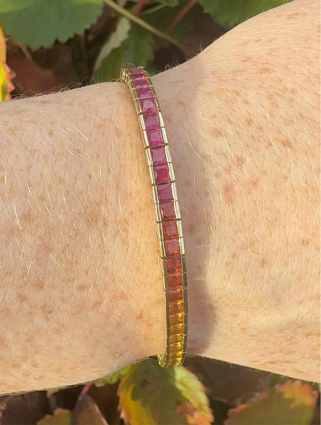 Rainbow sapphire deco style bracelet 14K yellow gold on wrist in natural light