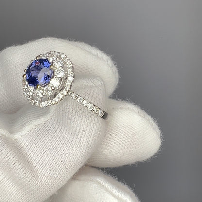 Cobalt blue spinel engagement ring held in white gloves