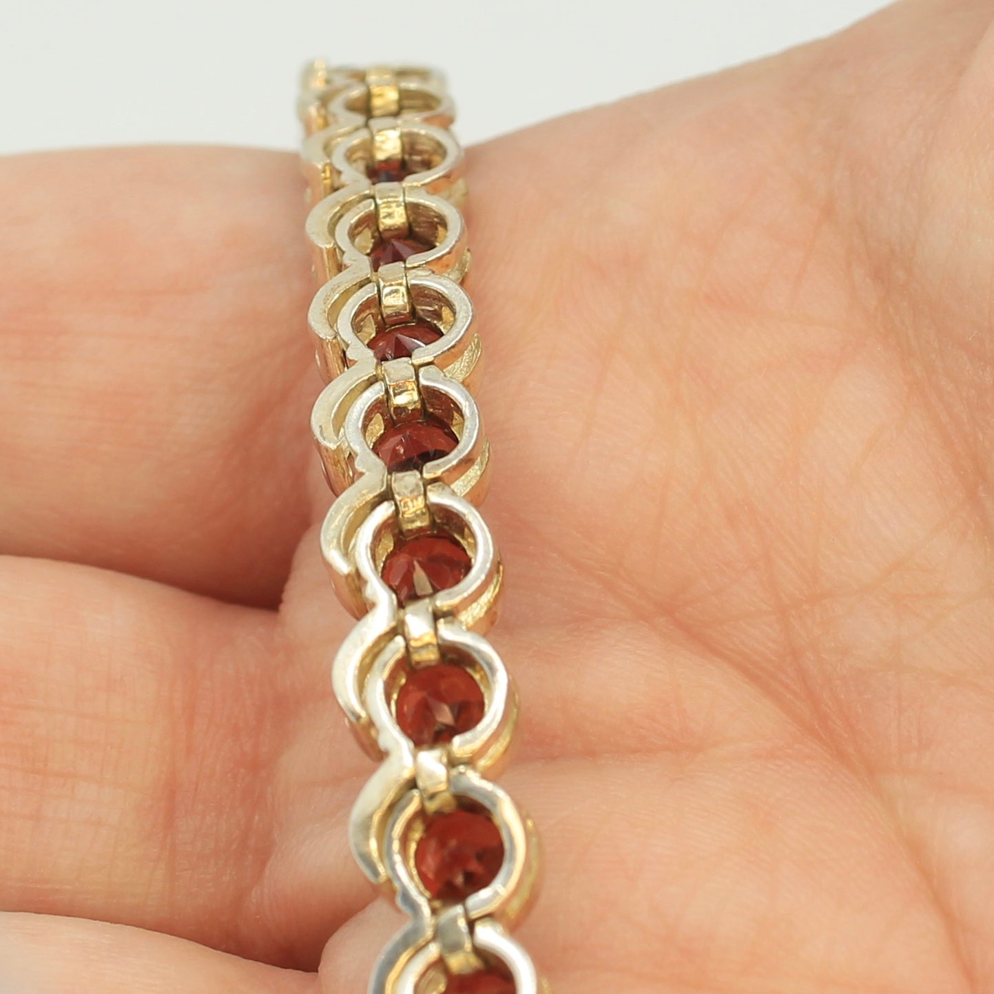 Backside of the red garnet tennis bracelet in hand