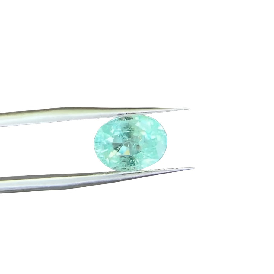 Paraiba Tourmaline Oval held by tweezers showing the nice blue color