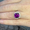 Video of the royal purple grape rhodolite garnet ring on a human hand. It is set in white gold with a diamond halo.