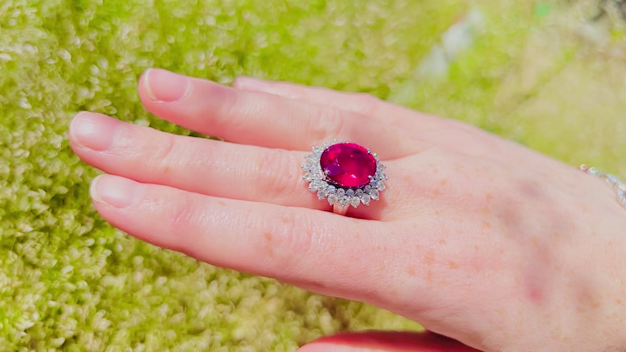 Load video: A hand with a white gold rubellite ring with a double halo and a pink spinel and diamond bracelet on the wrist.